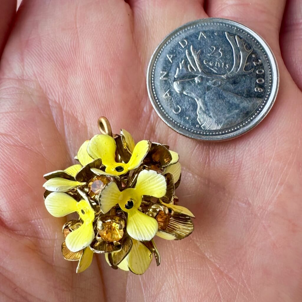 Vintage, Swarovski rhinestone, flower-style bead ball charm, with topaz-coloured stones and yellow petals, on a pink background.