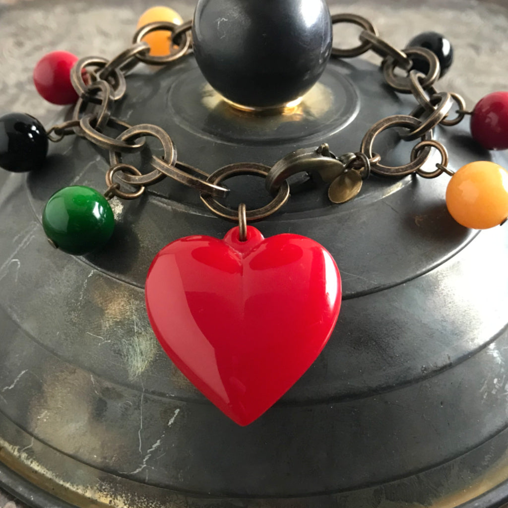 Suzie Q Studio carries HOTCAKES DESIGN retro-style, handmade jewelry taking its inspiration from classic Bakelite jewelry, vintage images and bold color.  This fun and festive charm bracelet will jazz up any outfit and make your heart sing with its luscious heart and colorful charms.