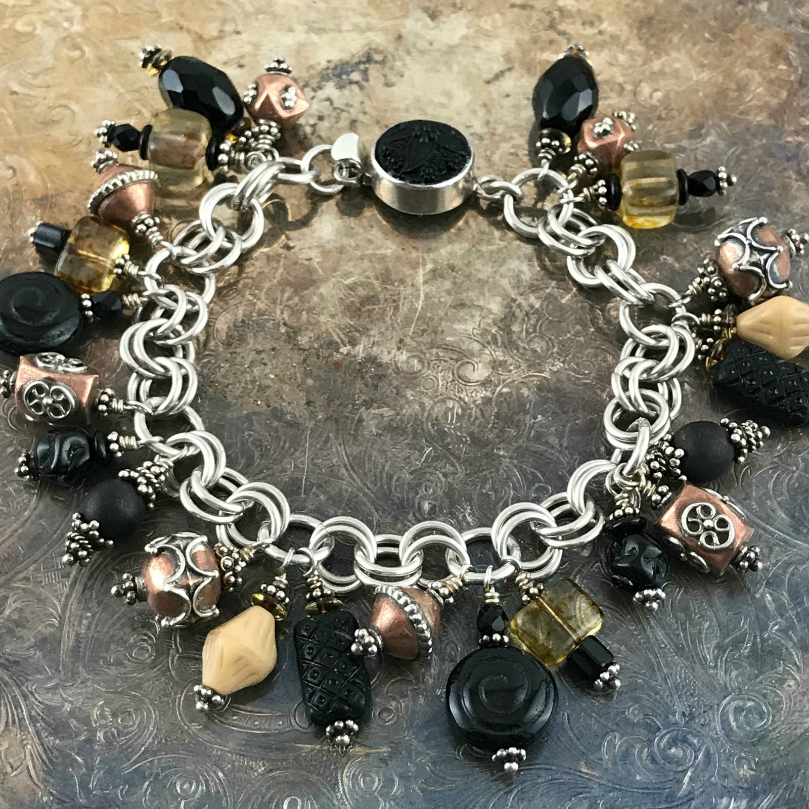 Available at Suzie Q Studio -- Czech glass, copper, sterling bead charm bracelet. The neutral colored bead-charms featured on this handcrafted sterling silver charm bracelet will go with a wide variety of styles and colors of outfits in your wardrobe. 