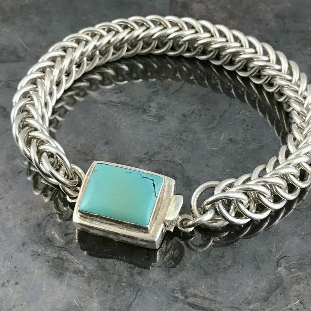 ​This striking Suzie Q Studio bracelet was created by hand-weaving 14 gauge, hand-cut, sterling silver jump rings into a pattern called “Half-Persian Weave”. Topped off with a sterling silver box-style clasp, which features a beautiful turquoise stone. Definitely a classic!
