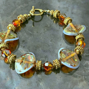 The individually made, handblown glass beads on this Suzie Q Studio bracelet are exquisite! Combined with Swarovski crystals, “vermeil gold” beads and toggle closure, makes this eye-catching bracelet perfect for almost any occasion.