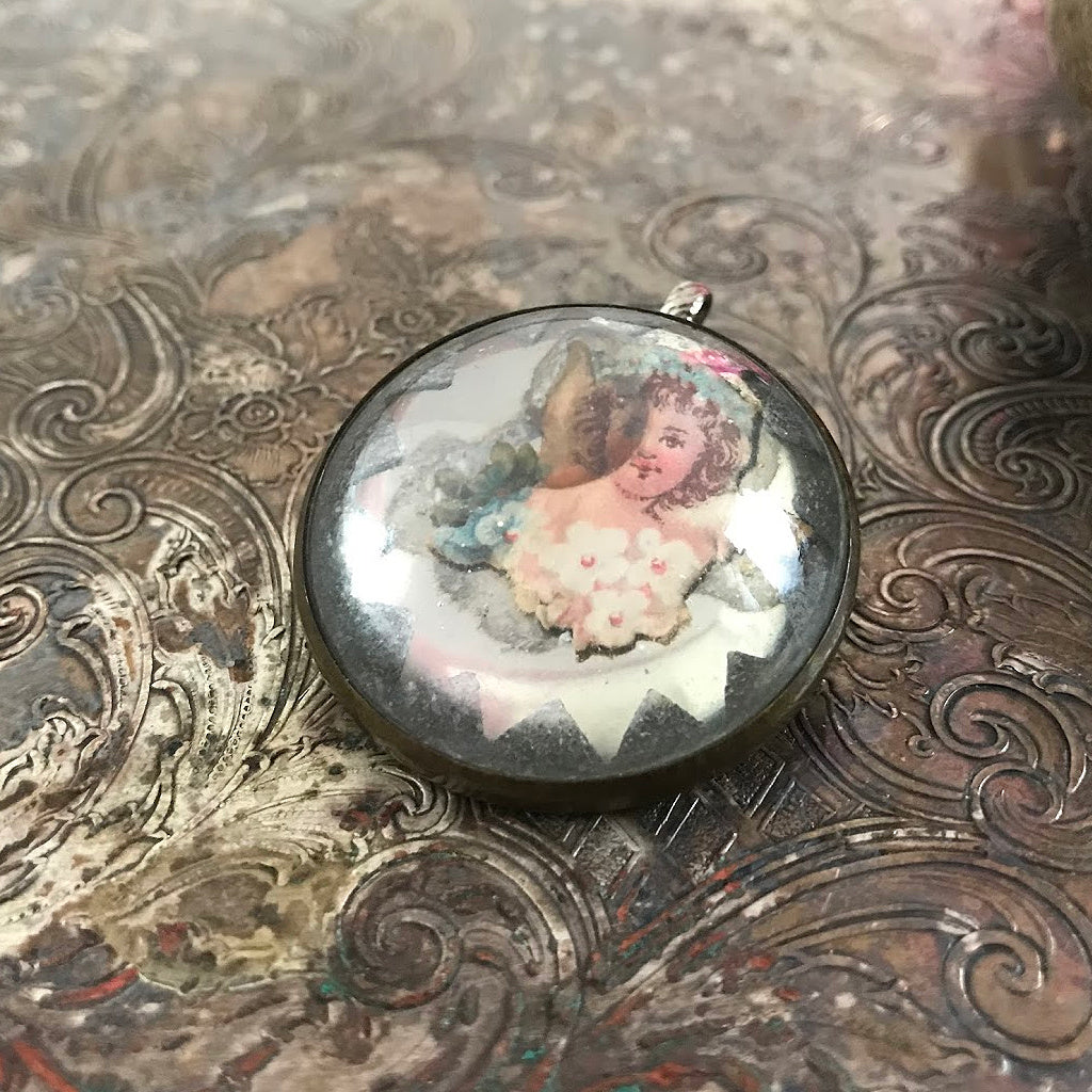 One-of-a-kind MY MOTHERS BUTTONS jewelry is handcrafted using the finest antique treasures. Glass-domed Horse Bridle Rosettes were a decoration for horse bridles. Suspended under the glass dome of this pendant is an angelic-looking flower girl image.  