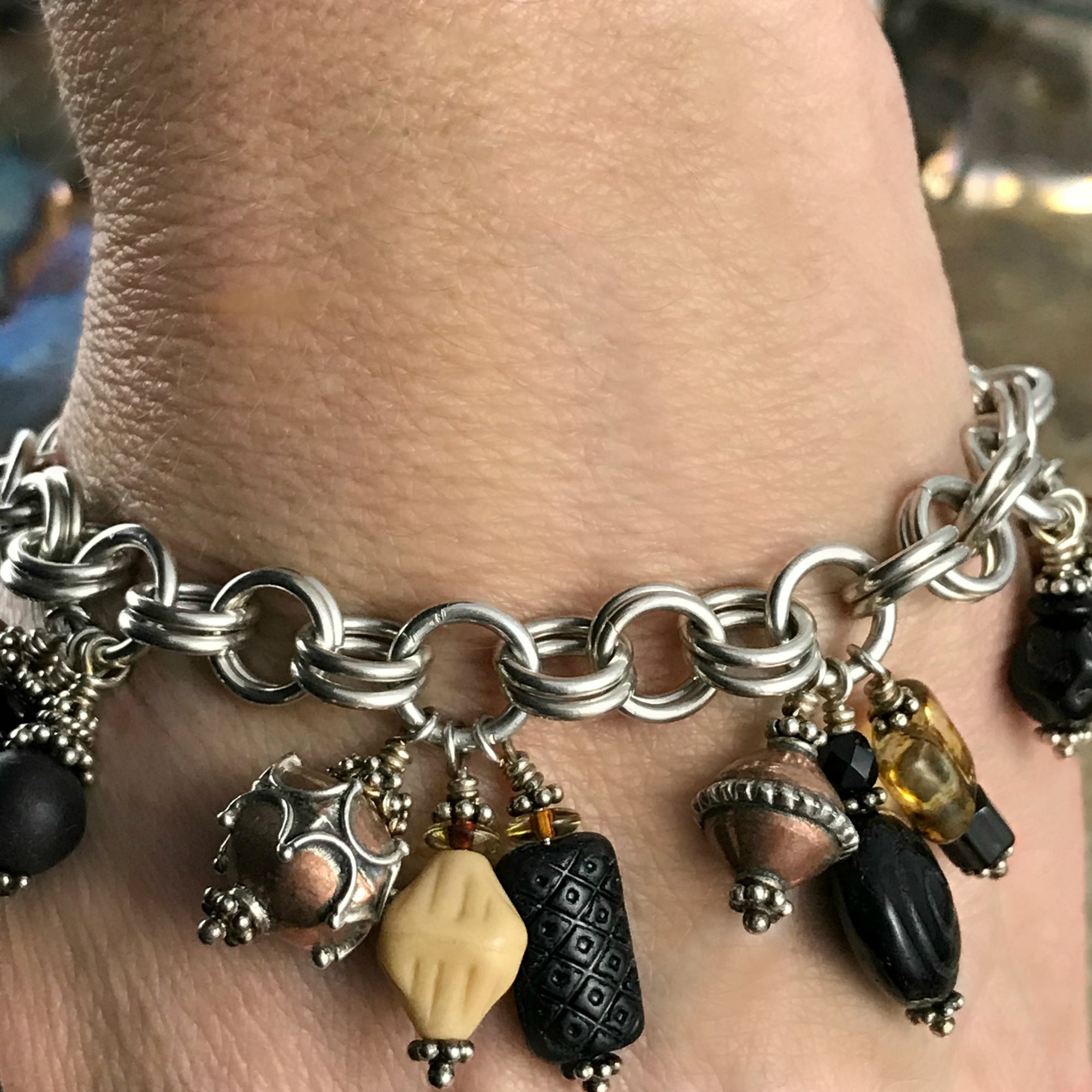Available at Suzie Q Studio -- Czech glass, copper, sterling bead charm bracelet. The neutral colored bead-charms featured on this handcrafted sterling silver charm bracelet will go with a wide variety of styles and colors of outfits in your wardrobe. 