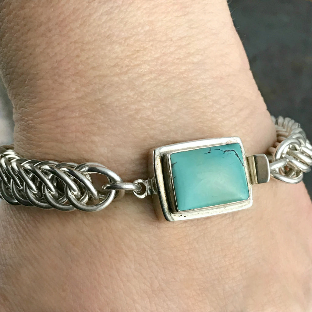 ​This striking Suzie Q Studio bracelet was created by hand-weaving 14 gauge, hand-cut, sterling silver jump rings into a pattern called “Half-Persian Weave”. Topped off with a sterling silver box-style clasp, which features a beautiful turquoise stone. Definitely a classic!