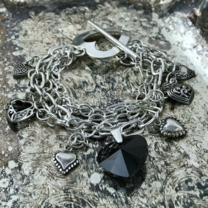 Suzie Q Studio -- Multi-strand sterling silver chain and charm bracelet. This sterling silver, multi-strand charm bracelet has a black Swarovski crystal heart focal charm, combined with sterling silver chain, charms and spectacular sterling silver, heart-shaped toggle-style clasp. 