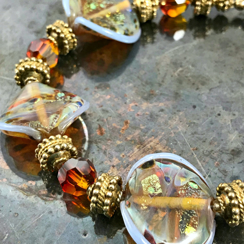 The individually made, handblown glass beads on this Suzie Q Studio bracelet are exquisite! Combined with Swarovski crystals, “vermeil gold” beads and toggle closure, makes this eye-catching bracelet perfect for almost any occasion.