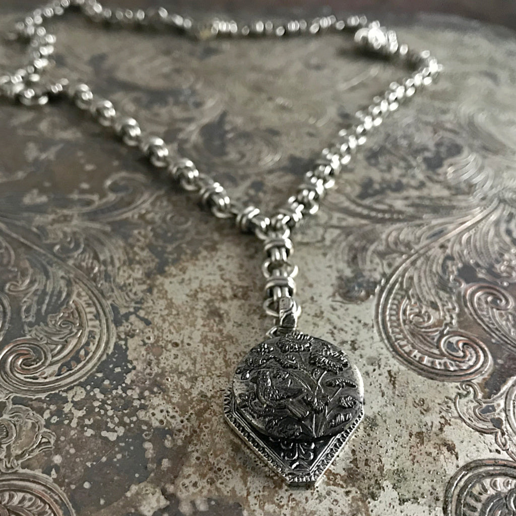 One-of-a-kind MY MOTHERS BUTTONS jewelry is handcrafted using the finest antique buttons. This “Y”-Style necklace has the most precious antique button of a little bird singing in the garden. 