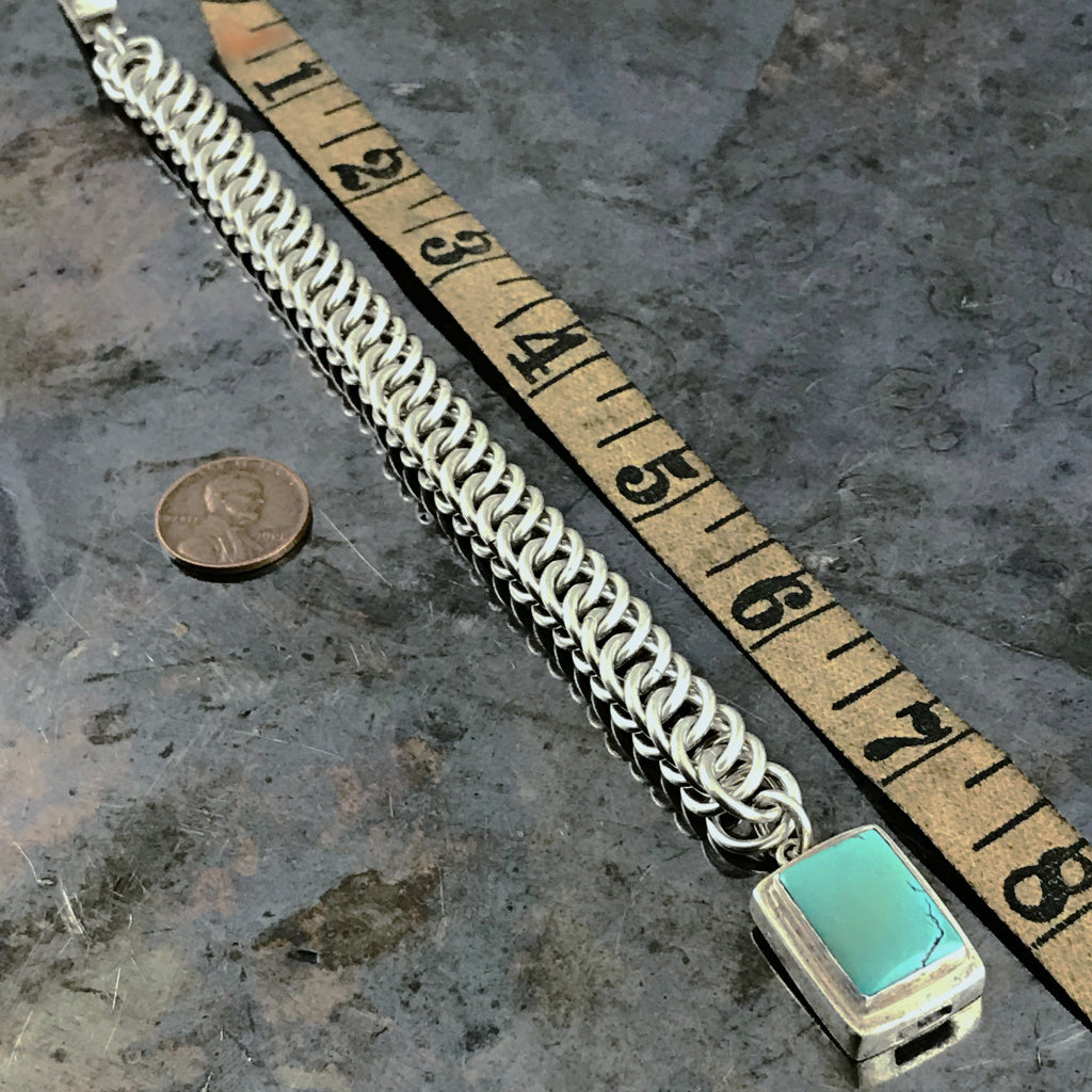 ​This striking Suzie Q Studio bracelet was created by hand-weaving 14 gauge, hand-cut, sterling silver jump rings into a pattern called “Half-Persian Weave”. Topped off with a sterling silver box-style clasp, which features a beautiful turquoise stone. Definitely a classic!