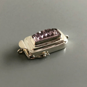 This Suzie Q Studio sterling silver custom box clasp was handcrafted with a skinny rectangle-shaped, vintage glass cabochon, with wonderful geometric ridges along the surface of it. The delicate, lilac-colored glass, juxtaposed with the strong carved lines, gives this box clasp a soft, yet dynamic look. 