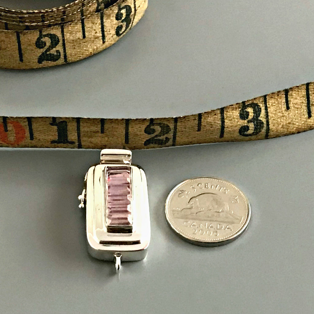 This Suzie Q Studio sterling silver custom box clasp was handcrafted with a skinny rectangle-shaped, vintage glass cabochon, with wonderful geometric ridges along the surface of it. The delicate, lilac-colored glass, juxtaposed with the strong carved lines, gives this box clasp a soft, yet dynamic look. 