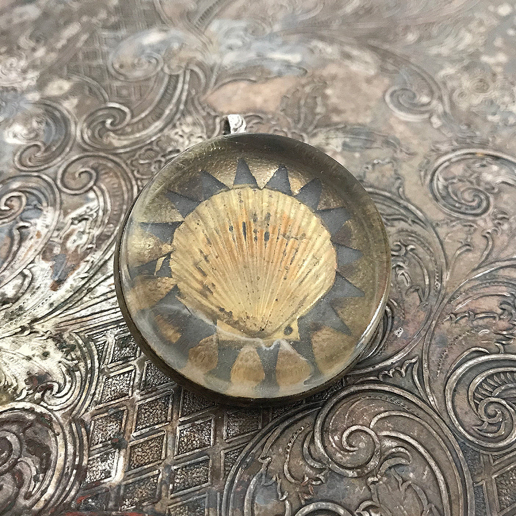 One-of-a-kind MY MOTHERS BUTTONS jewelry is handcrafted using the finest antique treasures. Glass-domed, bridle rosettes were a decoration for horse bridles. This pendant features a golden seashell design.