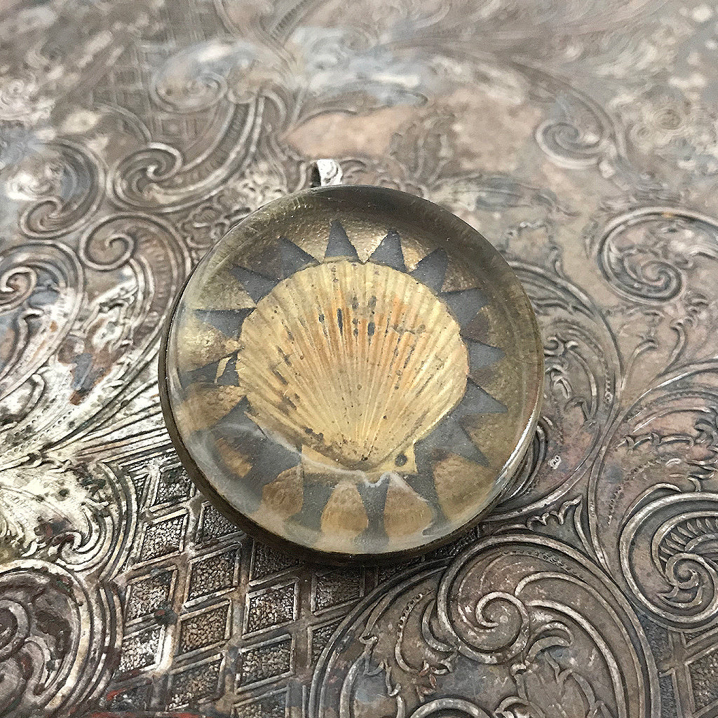 One-of-a-kind MY MOTHERS BUTTONS jewelry is handcrafted using the finest antique treasures. Glass-domed, bridle rosettes were a decoration for horse bridles. This pendant features a golden seashell design.