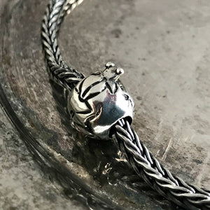 Suzie Q Studio has a treasure vault full of Rare and Retired Trollbeads... and we’re making them available to you. This rare, retired Sterling Silver Trollbead is decorated with frogs poking their heads out of the water, reflecting an image which Native Americans in the Southwest used to decorate their pottery.