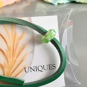 Trollbeads UNIQUES are one-of-a-kind glass beads handmade individually by 100% artisan-owned workshops. This Suzie Q Studio UNIQUES glass bead has green shamrock-style flowers that interlock with one another.