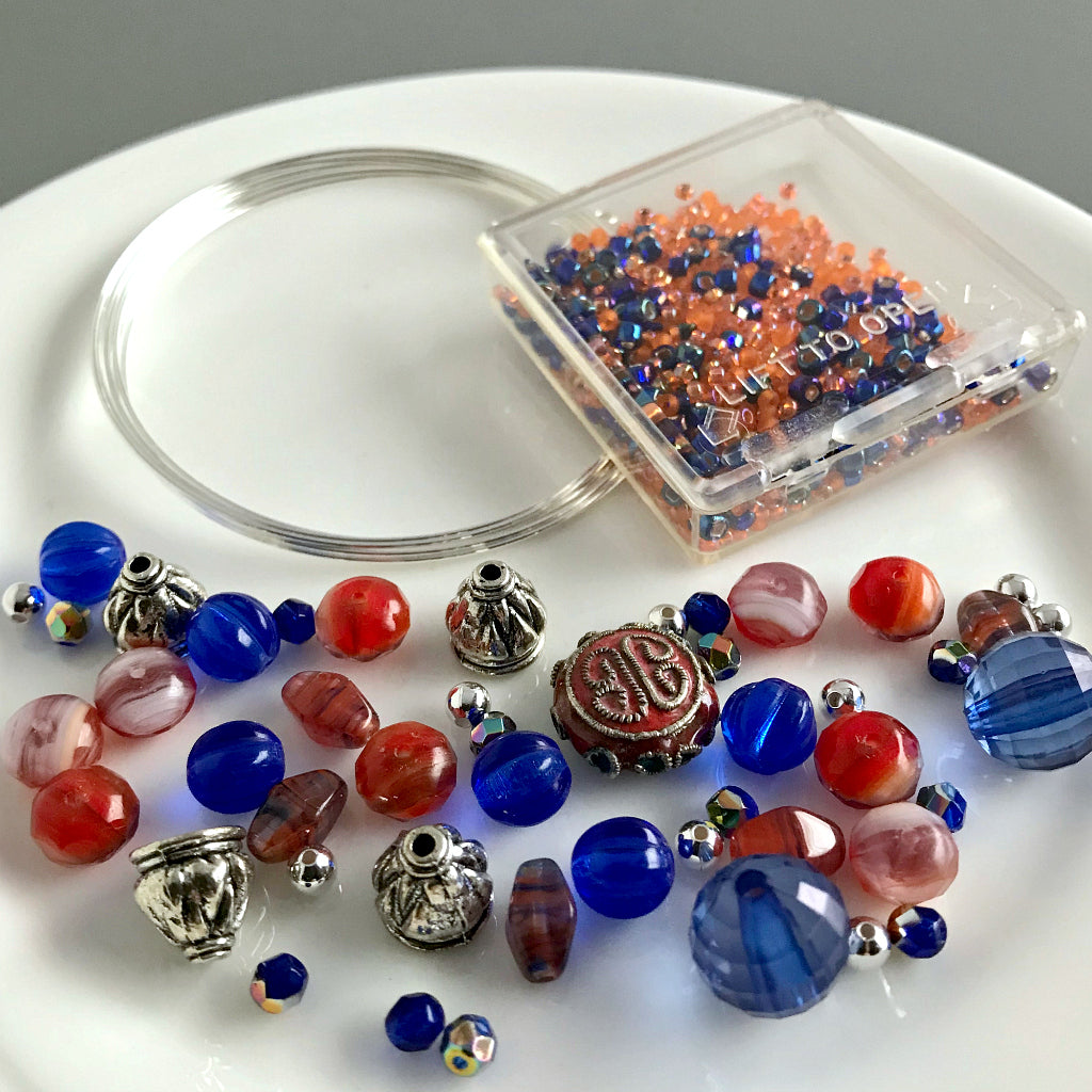 Suzie Q Studio's Serendipity BEAD STEW DIY EASY BRACELET MAKING KITS are limited edition collections of artfully curated premium quality beads and components for you to make a one-of-a-kind bracelet(s). No experience needed!  The SURF'S UP AT THE CRAB SHACK! kit contains various shades and tones of orangey-reds, cobalt blue, metallic silver, with a hint of mauve which will make you think of being at the beach.  