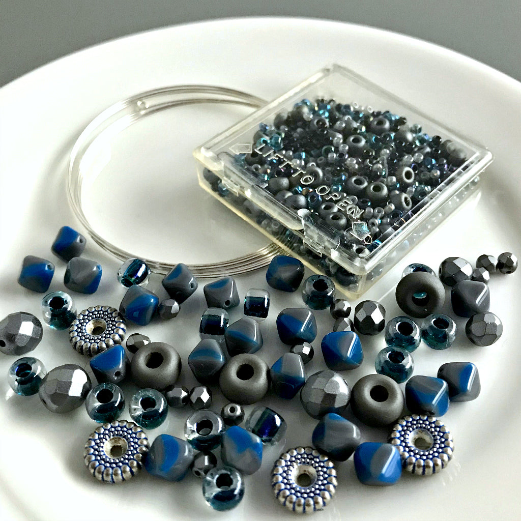 Suzie Q Studio's Serendipity BEAD STEW DIY EASY BRACELET MAKING KITS are limited edition collections of artfully curated premium quality beads and components for you to make a one-of-a-kind bracelet(s). No experience needed! "Cookie Monster" kit contains various shades of blues, including “Cookie Monster” blue, grey, metallic blue-grey, metallic silver.