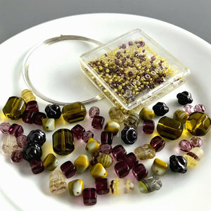 Suzie Q Studio's Serendipity BEAD STEW DIY EASY BRACELET MAKING KITS are limited edition collections of artfully curated premium quality beads and components for you to make a one-of-a-kind bracelet(s). No experience needed! The "Wine & Avocado Toast" Kit contains various shades of yellow-green, such as “olive” and “avocado", warm grey and purples.