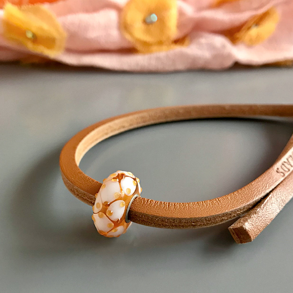 This sweet confection of a bead on Suzie Q Studio Trollbeads UNIQUES glass bead bracelet looks like honey on waffles and has a colour-coordinated leather bracelet. UNIQUES are great layered on your wrist and make wonderful gifts!
