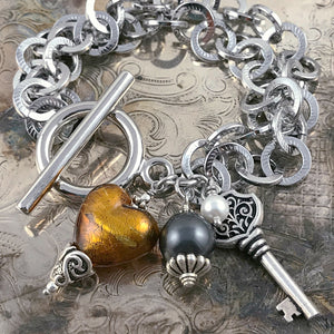 This Suzie Q Studio one-of-a-kind bracelet features a gorgeous, amber-coloured, handblown Italian Murano glass heart, a key charm, as well as Swarovski glass pearl accents and the neutral colours will coordinate with just about any outfit in your closet. 