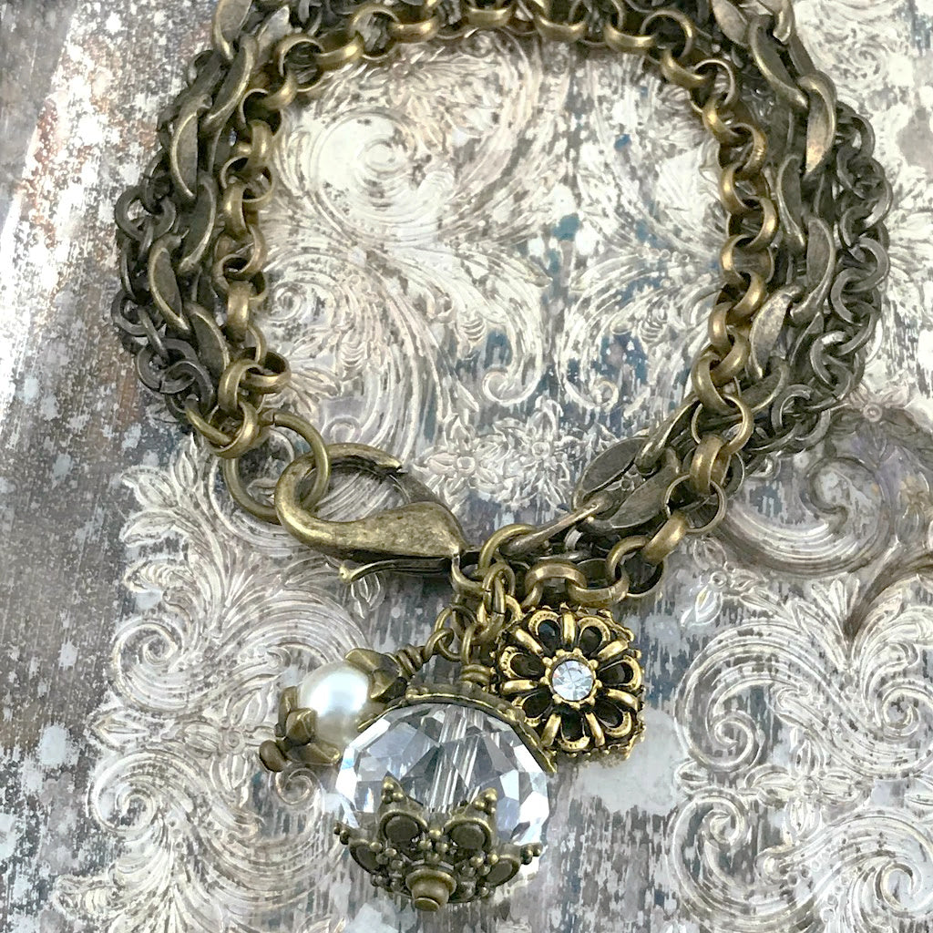 The crystal and pearl charms suspended from multiple strands of antique bronze-coloured chain, give this gorgeous, one-of-a-kind Suzie Q Studio bracelet a romantic feel from days gone by.