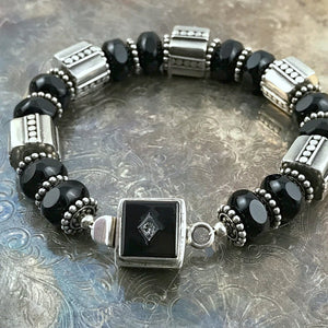 The exquisite sterling beads in this Suzie Q Studio bracelet are combined with a secure, vintage glass, sterling silver box-style clasp and black Czech pressed-glass beads to give this bracelet a timeless, classic look.