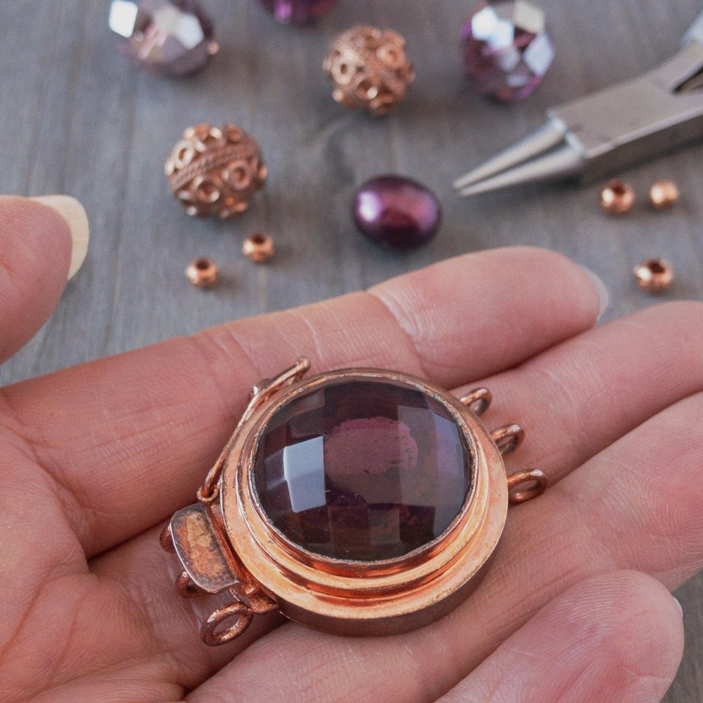 This unique box clasp showcases a warm, amethyst-coloured, vintage, faceted glass cabochon, and is surrounded by copper that has a beautiful natural, antique patina finish. It was individually handcrafted in 100% pure copper, exclusively for Suzie Q Studio.