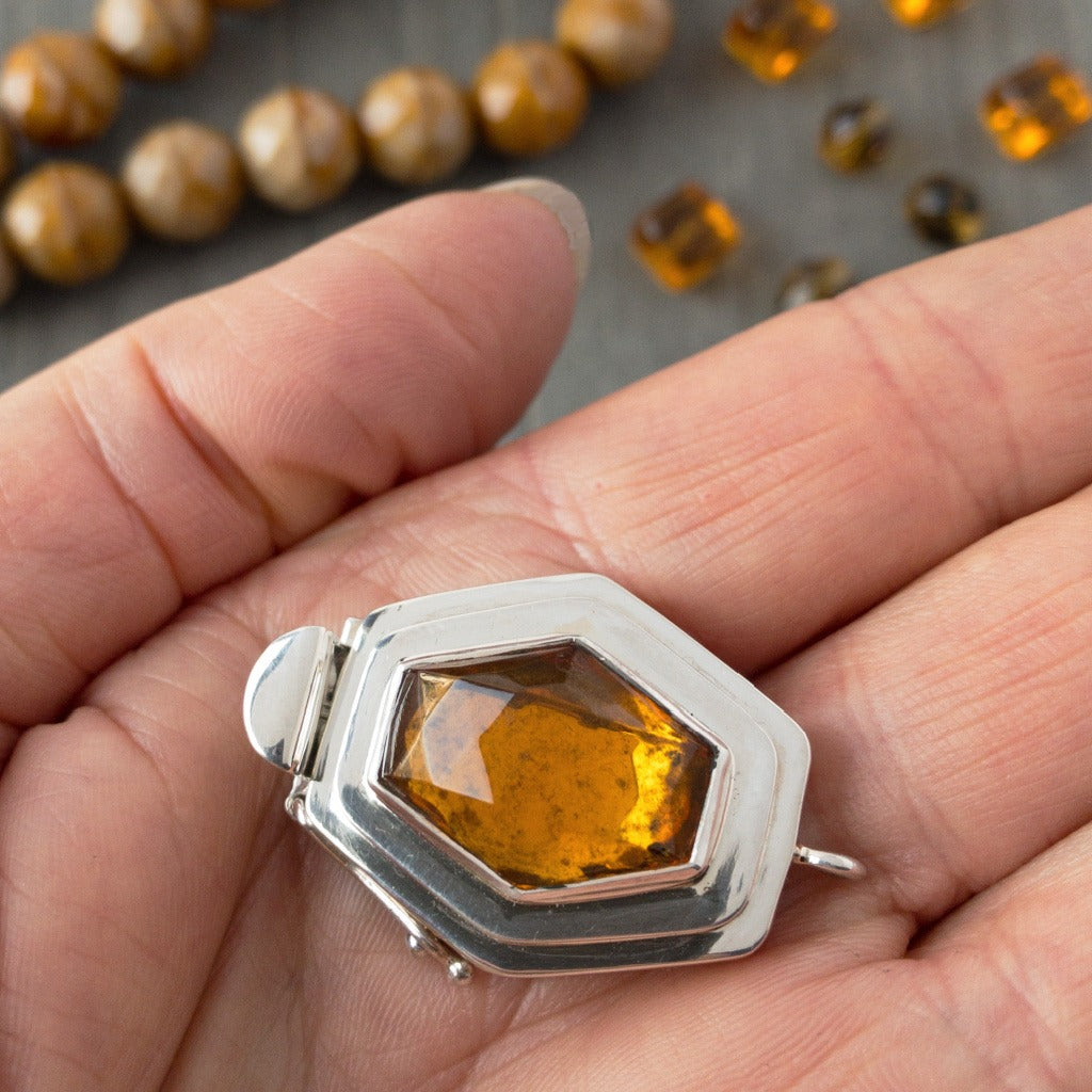 In addition to the uncommon diamond shape of the vintage glass cabochon in this sterling silver box clasp, the rich amber colour gives this piece an ultra-luscious look that would totally lend itself to mixing gold metal with the silver, if you so desired.