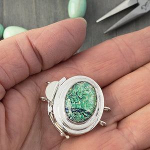 The metallic-effect of the vintage glass cabochon stone in this double strand, sterling silver box clasp is called a  "harlequin" finish, which is extremely popular, and this blue-green version is exquisite!