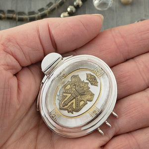 This unusual triple-strand, sterling silver box clasp features a three-dimensional, antique gold crest floating under a dome of clear glass, on a base of silver-leaf. The outer border is also 3-D, with a lovely antique gold design etched into the glass... A truly spectacular, focal-piece clasp!