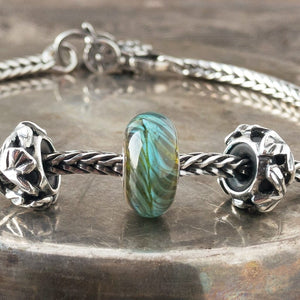 Suzie Q Studio's BLUE-GREEN FEATHER Trollbead is a beautiful blue and green with just a hint of turquoise. Constantly moving, forever changing like a blue-green feather in elusive flight. Visit Suzie Q Studio for new stock, never worn, collectible Rare & Retired Trollbeads.