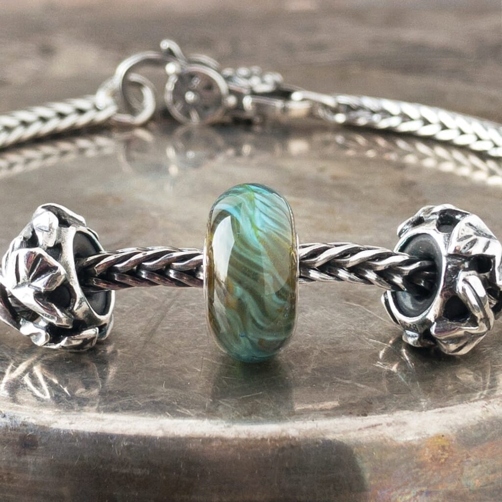 Suzie Q Studio's BLUE-GREEN FEATHER Trollbead is a beautiful blue and green with just a hint of turquoise. Constantly moving, forever changing like a blue-green feather in elusive flight. Visit Suzie Q Studio for new stock, never worn, collectible Rare & Retired Trollbeads.