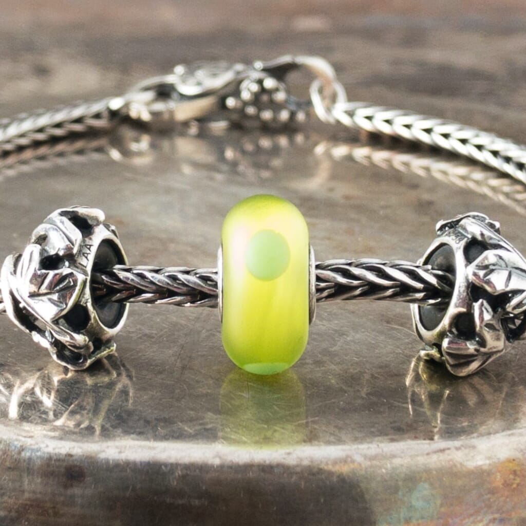 The sandblasted surface of Suzie Q Studio's Green Sand Trollbead absorbs and softens the light in this brightly-coloured bead giving it a luscious inner glow. Visit Suzie Q Studio for new stock, never worn, collectible Rare & Retired Trollbeads.