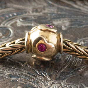 Limited Edition, 18-Karat Gold "heartbeat" Trollbead with four beautiful rubies, worn on an 18KT gold Trollbeads bracelet.